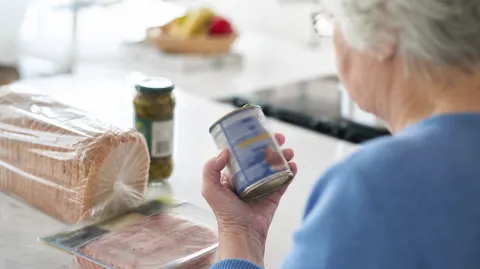 Soup, bread, deli meat and pickles on a kitchen counter