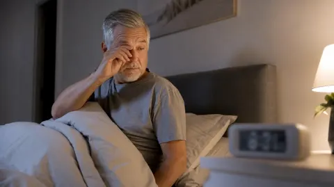 A man awake in bed in the middle of the night